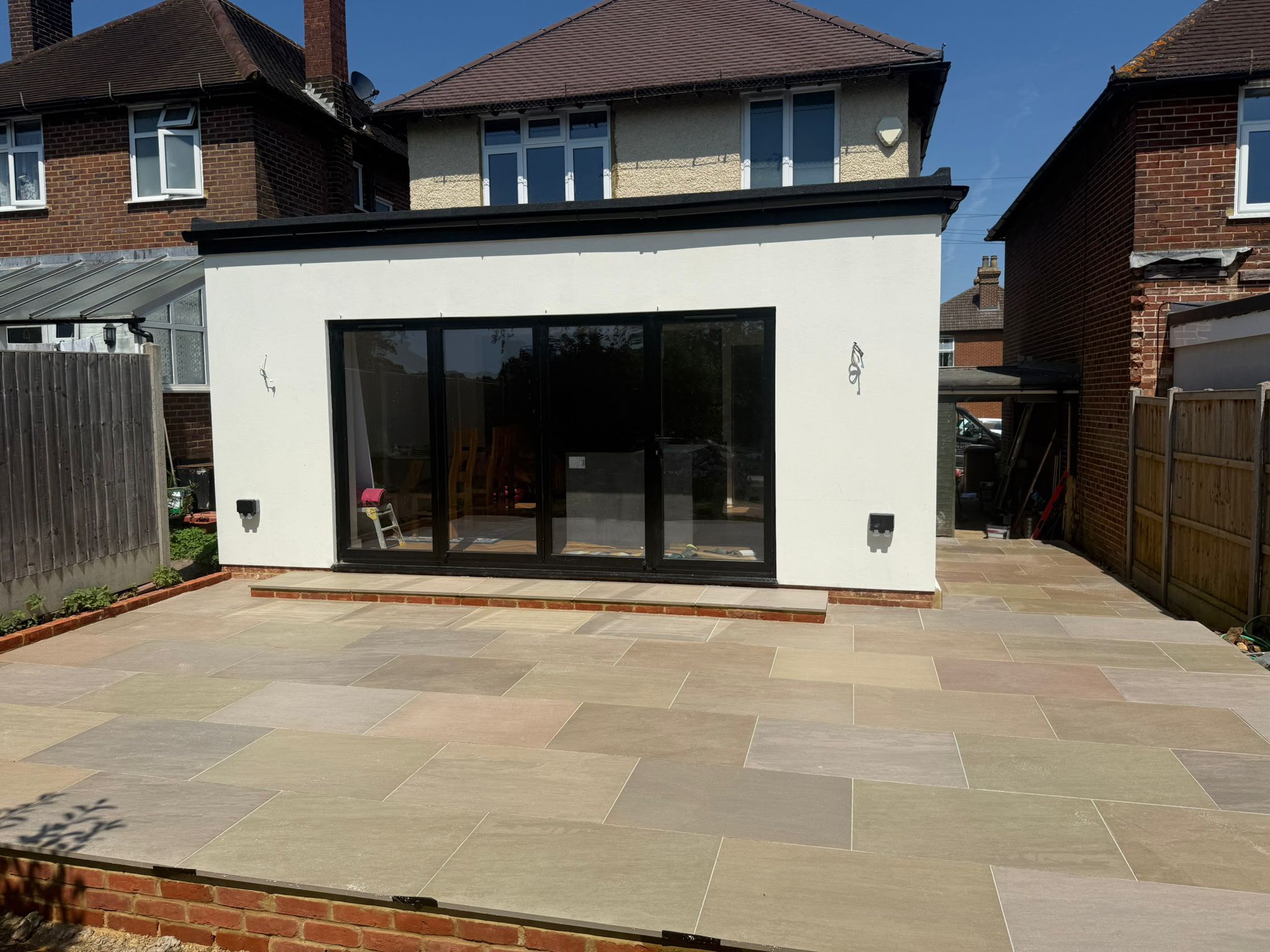 Completed rear extension with a paved patio and wide bi-fold doors